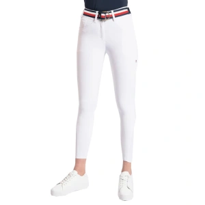 woman stood facing forward in tommy hilfiger geneva all-year knee grip breeches in optic white with a pair of white trainers on and a tommy hilfiger belt
