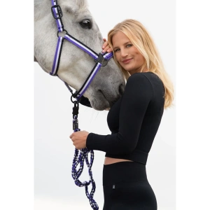 The Eskadron Double Pin Headcollar Dynamic in black, white, and purple is a stylish yet highly functional accessory for your horse. Designed for both durability and comfort. This headcollar is made from high-quality tear-proof webbing. Ensuring long-lasting strength while remaining lightweight and flexible for everyday use. A standout feature of this headcollar is the bold Eskadron noseband print. Which adds a striking and modern touch to its design. The combination of black, white, and purple gives it a sporty and elegant look. Making it a great choice for riders who appreciate both performance and aesthetics in their equestrian gear.